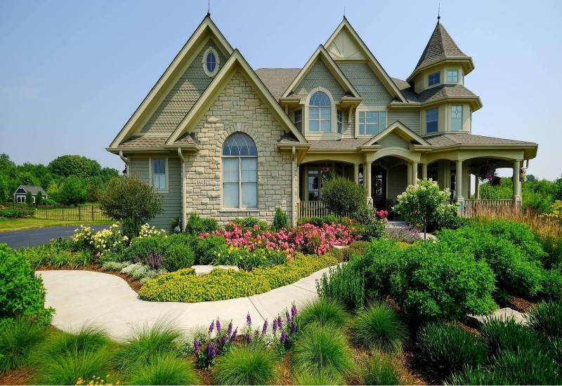 A large house surrounded by beautifully varied landscaped plants in DuPage County, IL
